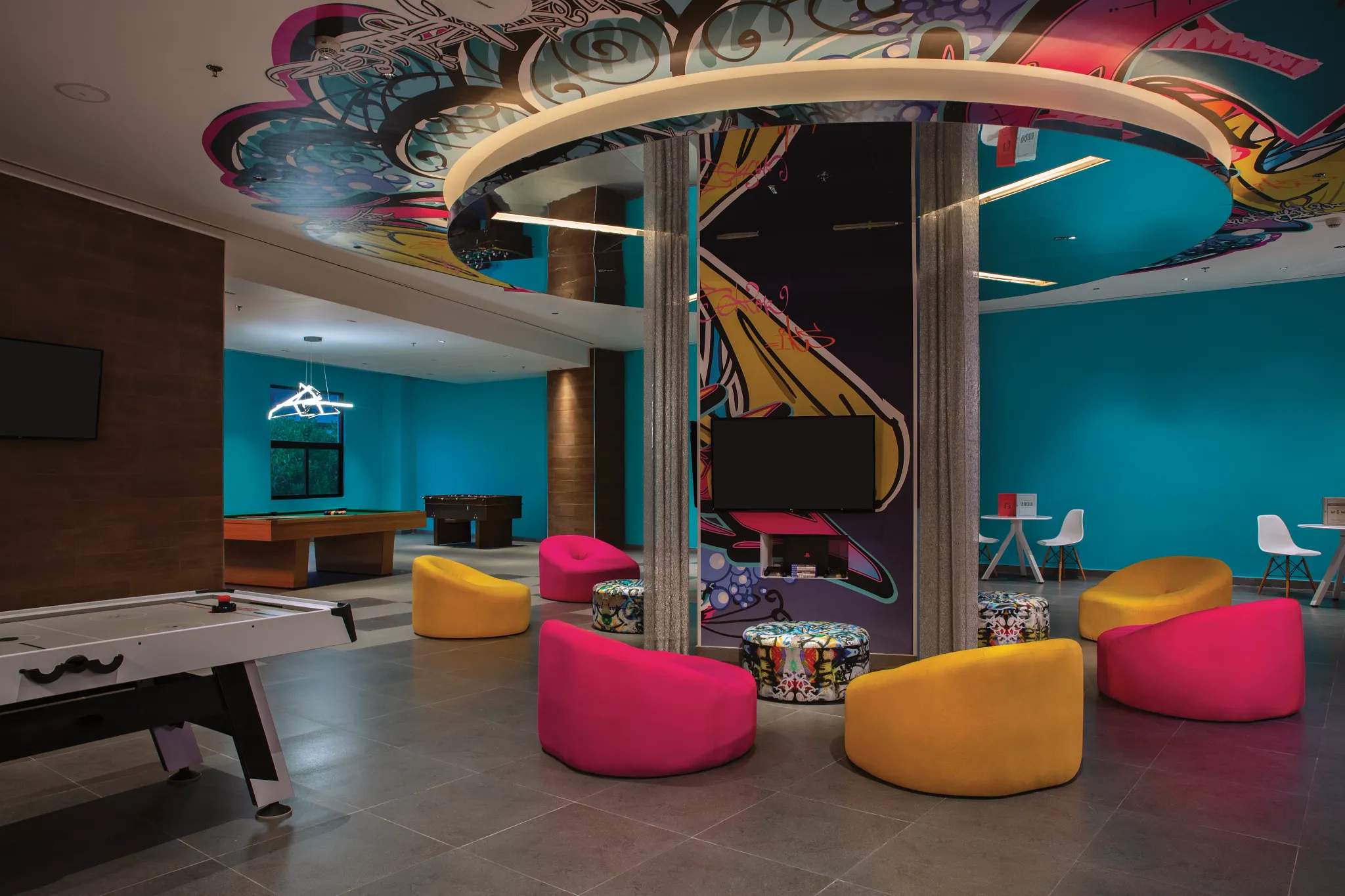 Colorful teen lounge with games, pool table, and seating at Dreams Natura Resort & Spa Core Zone for teens.