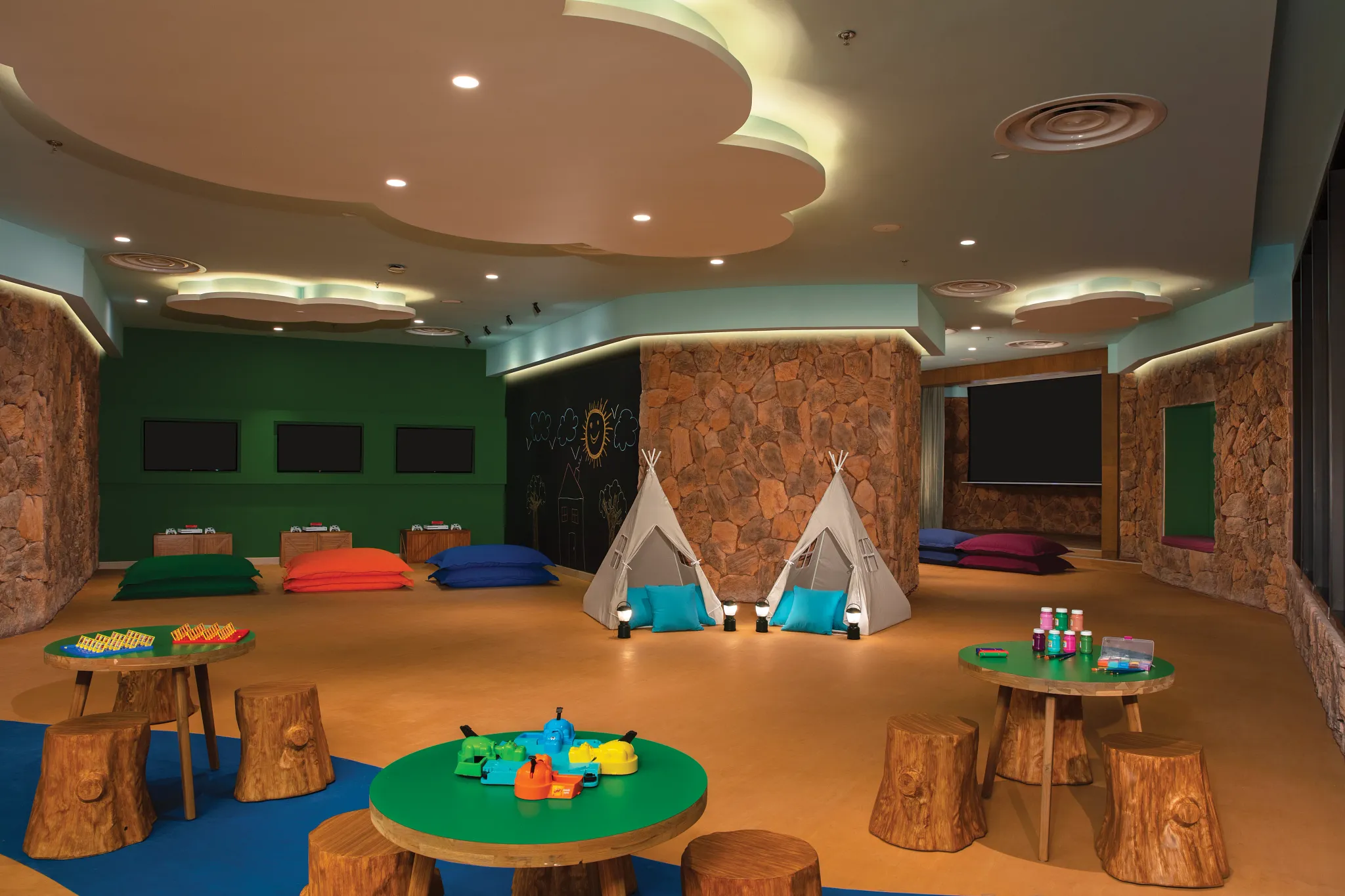 Kids play area with teepees, games, and colorful seating at Explorer’s Club in Dreams Natura Resort & Spa.