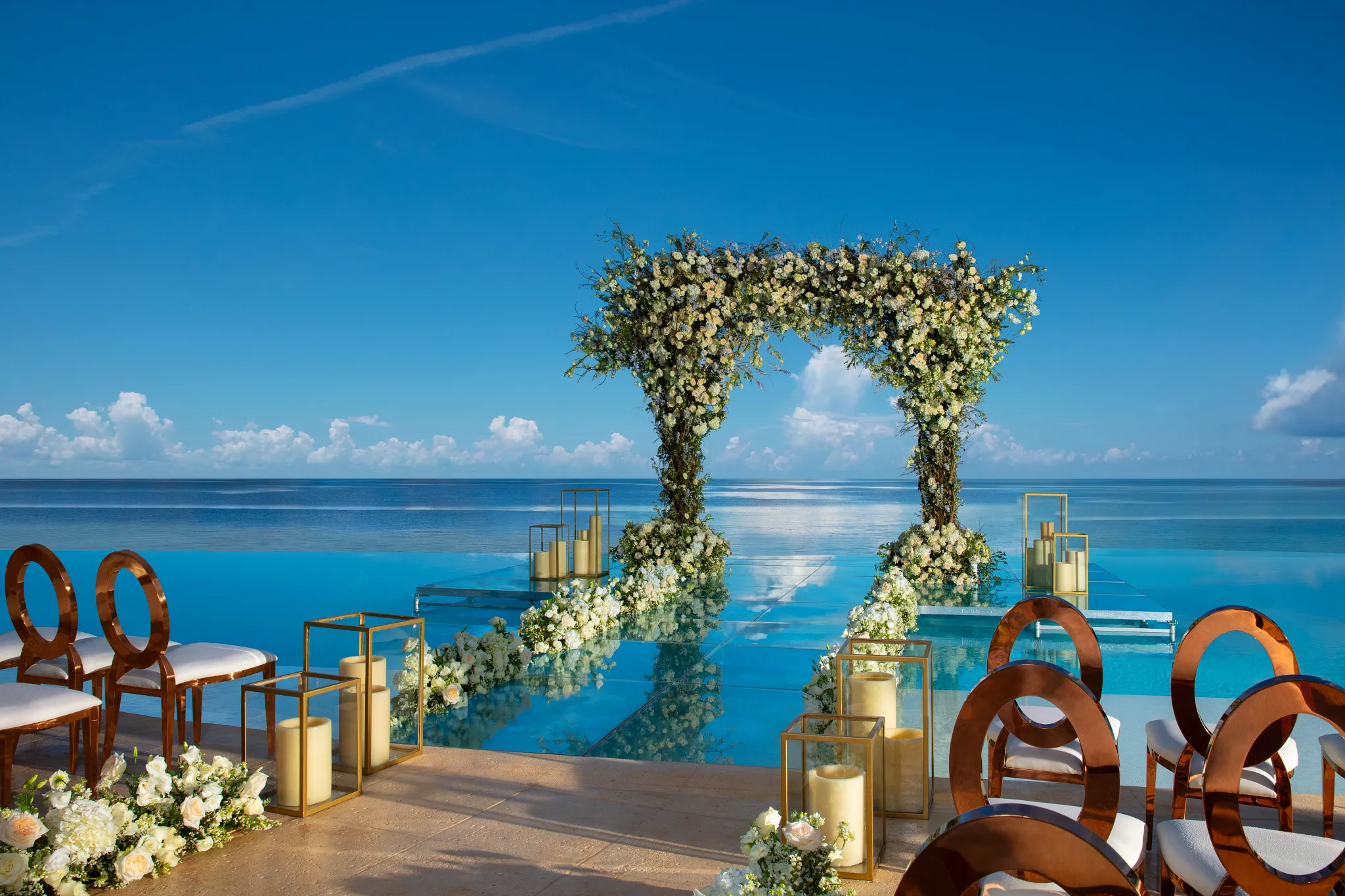 Infinity pool wedding reception setup overlooking the ocean at Dreams Natura Resort & Spa