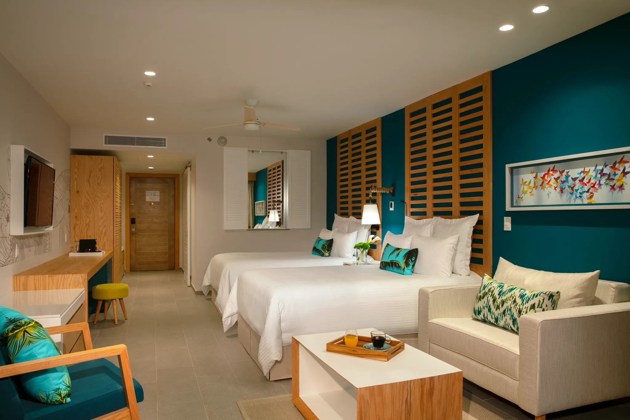 Junior Suite Tropical View with two double beds and seating area at Dreams Natura Resort & Spa.