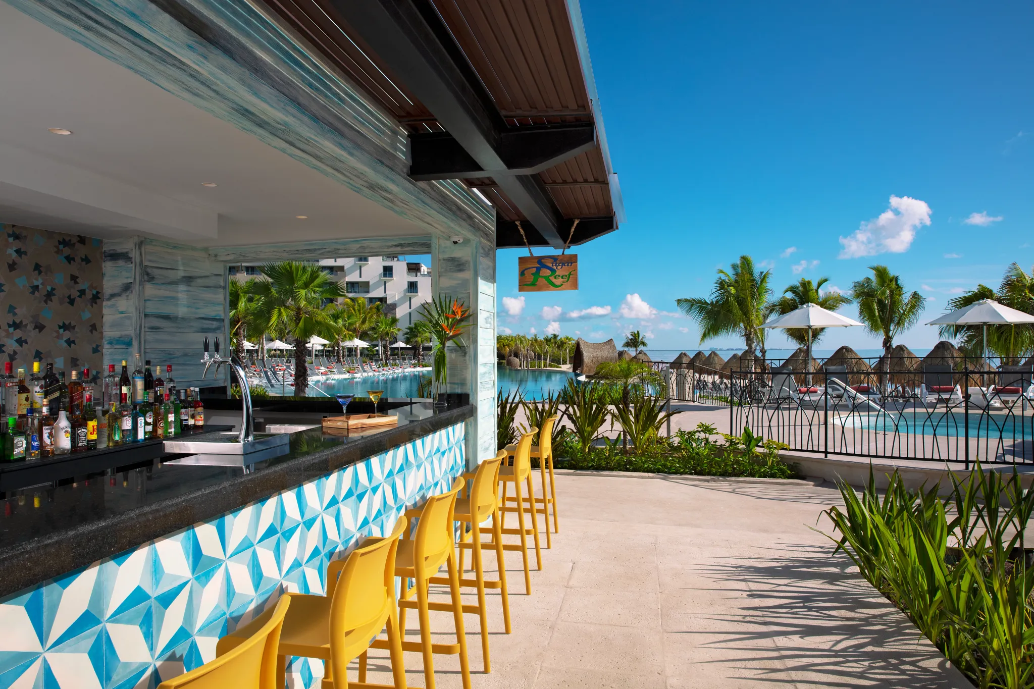 Sugar Reef poolside bar at Dreams Natura Resort & Spa featuring a relaxed setting, tropical cocktails, and sunny pool views.